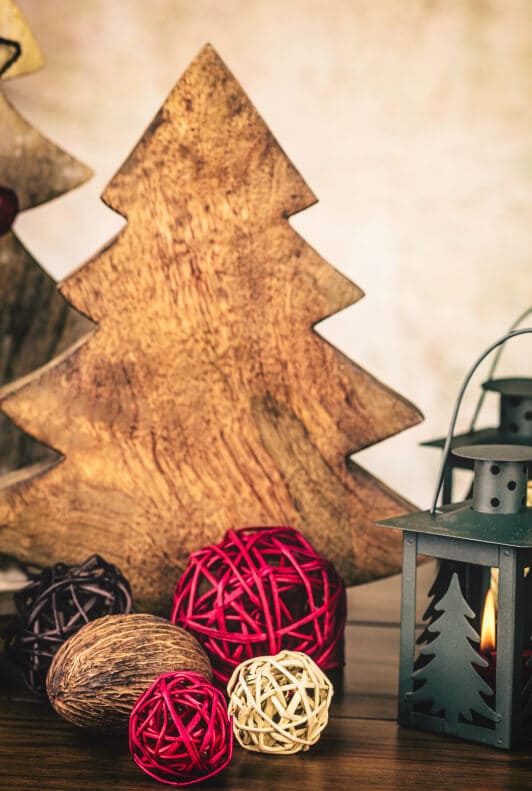 Holzbaum und Weihnachtsdekoration mit Laterne und Rattankugeln