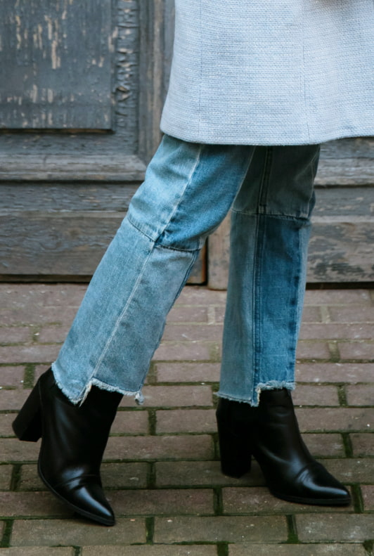 Close-Up von schwarzen Ankle Boots und blauer Jeans